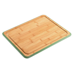 Zöld szegélyes bambusz vágódeszka bemélyedéssel.