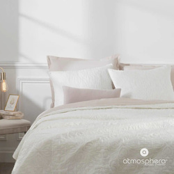 Dekoratív takaró párnahuzatokkal, elefántcsont színben.